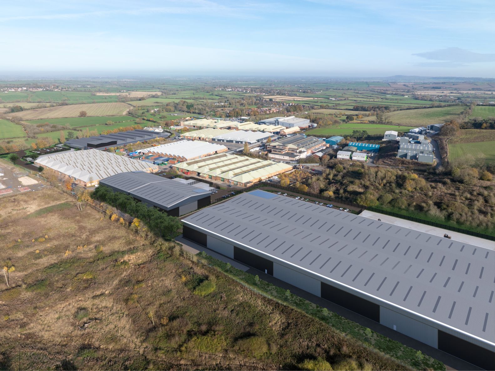 Toyota 3 Aerial view of industrial warehouse development alongside an established business park and surrounding countryside.